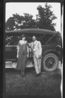 Man and woman standing next to a car